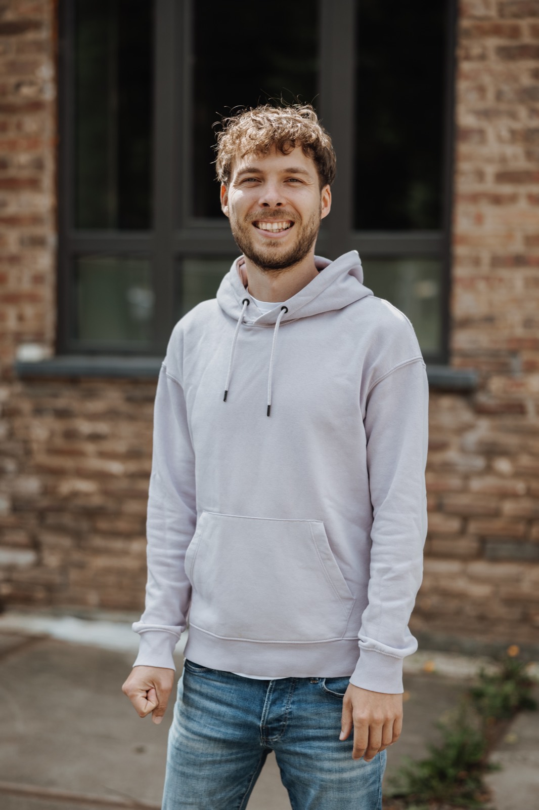 Heinz laughing in front of a brick wall in Belgium.