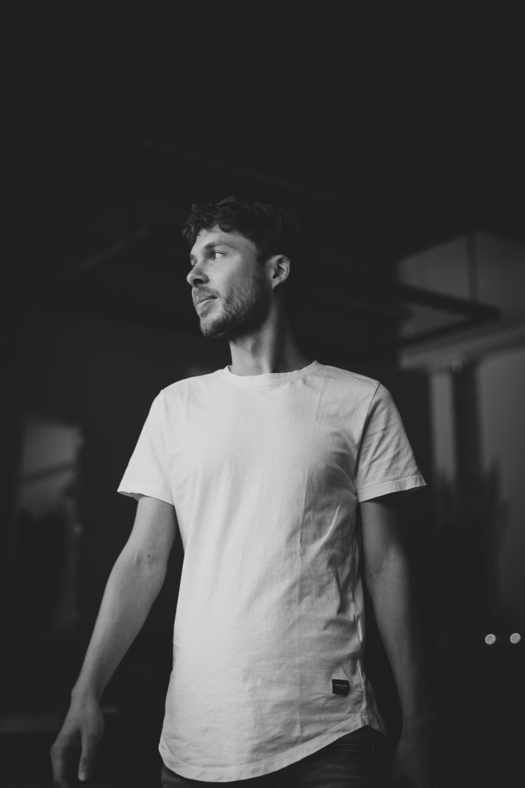 Heinz in half-darkness, his gaze turned sideways into the light. Black and white photograph.